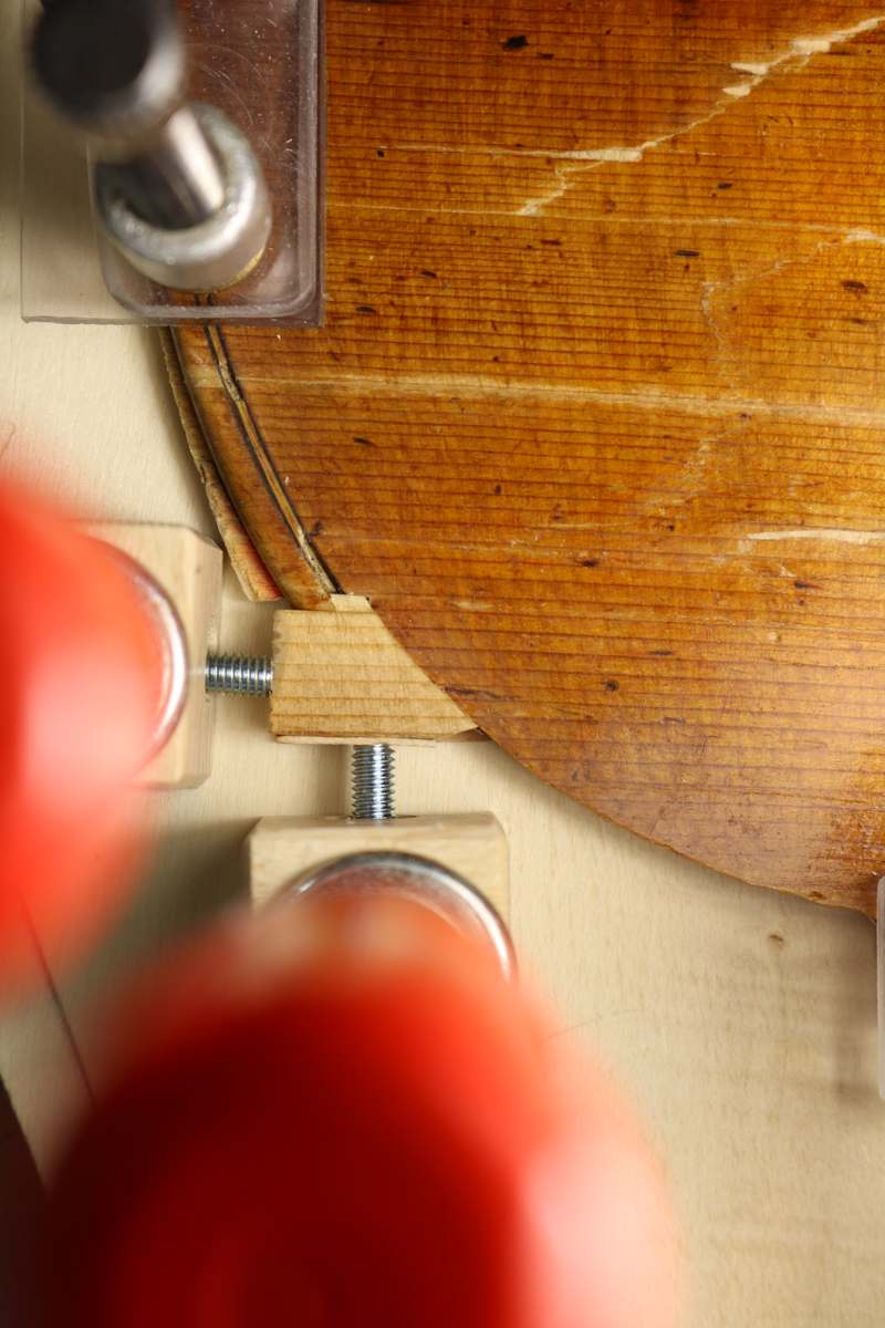 Clamp holding a cleat while the glue sets